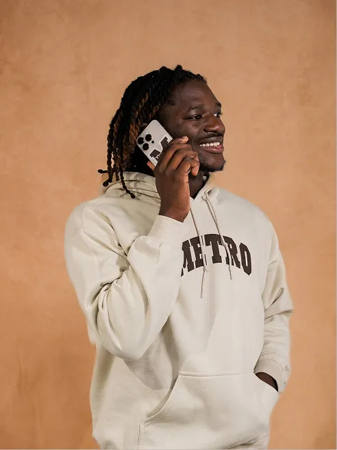 A model in a cream Metro crewneck, phone to his ear.